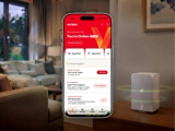 Verizon home-network dashboard displayed on a phone beside a wireless router